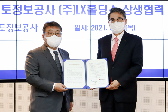 From left, LX Holdings CEO Song Chi-ho and LX CEO Kim Jung-ryul sign a memorandum of understanding at LX's Seoul office in Gangnam, southern Seoul, Thursday. [LX HOLDINGS]
