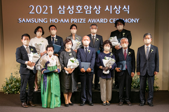 Stanford University Professor Huh June, second from left in the back row, Seoul National University Professor Kaang Bong-kiun, fourth from left in the back row and director Bong Joon-ho, fifth from left in the back row, pose alongside family members representing New York University Professor Cho Kyung-hyun, Johns Hopkins University Professor Lee Dae-yeol and Lee Seok-ro, head of a medical center in Bangladesh. The six honorees were awarded the Samsung Ho-am Prize for their achievements in various sectors by Ho-am Foundation Chairman Kim Hwang-sik, right, at the Hotel Shilla in central Seoul on Tuesday. [YONHAP]