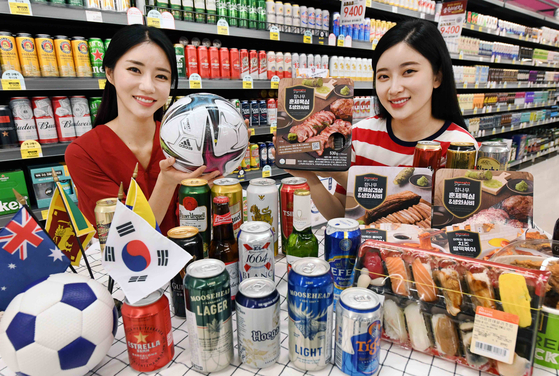 Models pose to promote a Homeplus sale celebrating the Korean football team's World Cup qualifying matches scheduled in June. The sale will run from Thursday to June 9, offering canned beer and popular anju, or snacks for drinkers, such as beef and jerky at discounted prices. [YONHAP] 