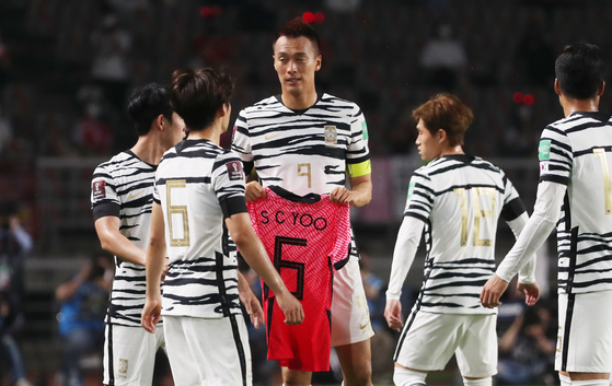 Korean players celebrate their first goal by holding up a uniform in memory of former national team star Yoo Sang-chul, who died Monday. [NEWS1]