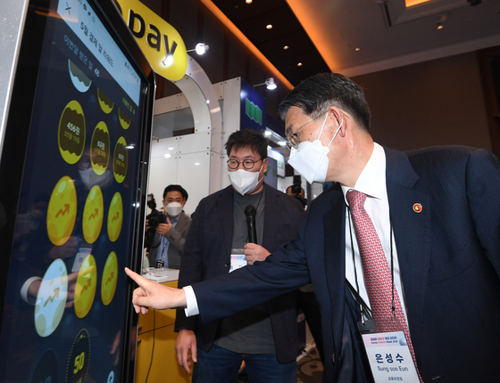 Financial Services Commission Chairman Eun Sung-soo tests some of the technology of KakaoPay displayed during Korea Fintech Week, an FSC exhibition, held in Yeouido last month. [YONHAP] 