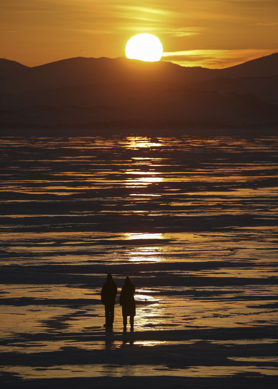 Tourists enjoy a sunset view of Lake Baikal near the village of Shida on March 7. [NATALIA FEDOSENKO/TASS/YONHAP]