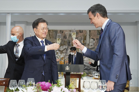 President Moon Jae-in, left, and Spanish Prime Minister Pedro Sanchez, right, toast each other at the Prime Minister’s Palace in Madrid on Wednesday.  [BLUE HOUSE]