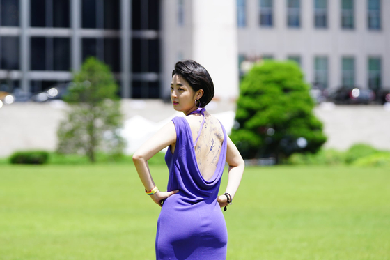 Rep. Ryu Ho-jeong of the Justice Party revealed a back full of erasable tattoos as part of a campaign to liberalize regulations on tattooing Wednesday at the National Assembly compound in Yeouido, western Seoul. [YONHAP]