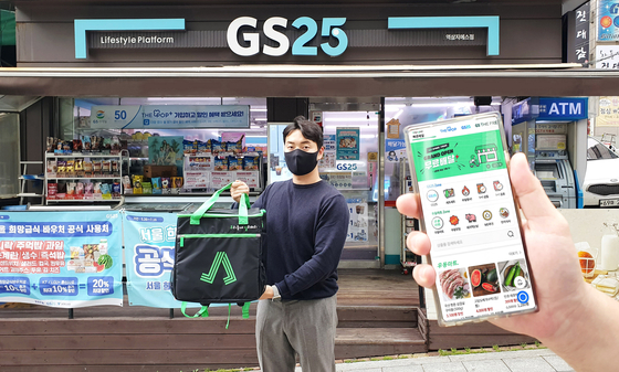 A model promotes GS25's delivery app Woodel on Monday. The company said it launched a mobile app for its delivery service for convenience store GS25 and GS Supermarket, which was previously only available either through Yogiyo app or KakaoTalk. [YONHAP]