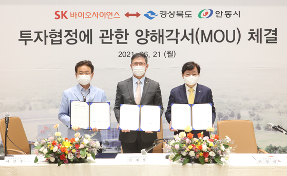 SK Bioscience CEO Ahn Jae-yong, center, poses for a photo with North Gyeongsang Gov. Lee Cheol-woo, left, and Andong City Mayor Kweon Young-sae after signing a memorandum of understating to expand production capacity of its vaccine factory and purchase new land on Monday at L House in Andong, North Gyeongsang. [SK BIOSCIENCE]