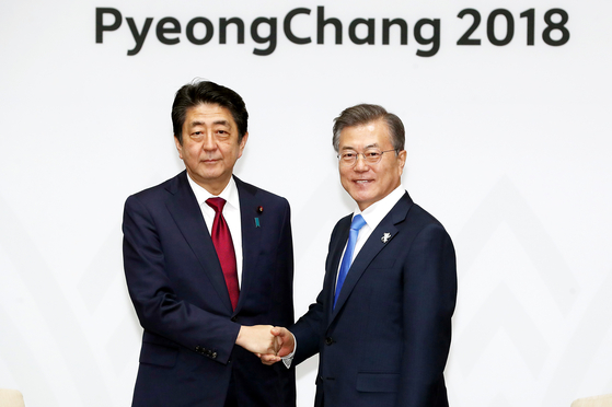 In this file photo, President Moon Jae-in, right, and Japanese Prime Minister Shinzo Abe stand for a photo before their summit in Yongpyeong, Gangwon Province, on the sidelines of PyeongChang Winter Olympic Games in 2018.  [Presidential Press Corps]
