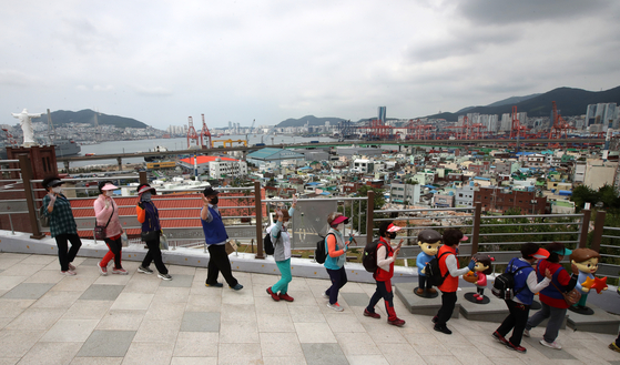 Busan residents walk along the northern harbor of the port city on Wednesday to express their support for the Busan city government's bid to host the World Expo in 2030. [SONG BONG-GEUN]