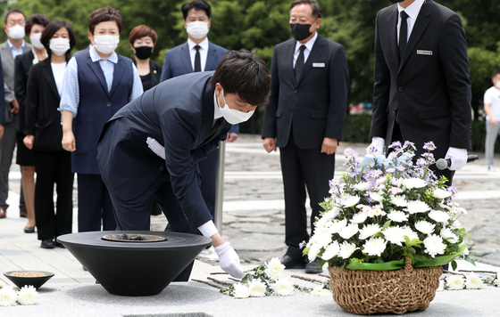 People Power Party Chairman Lee Jun-seok lays a flower before the grave of the late President Roh Moo-hyun in Bongha Village in South Gyeongsang Friday.  [YONHAP] 