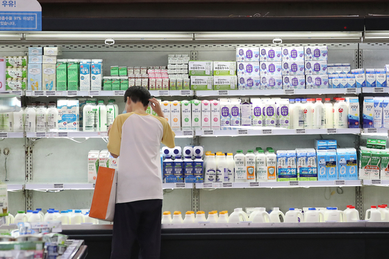 A customer shops for milk at a big discount mart in Seoul on Sunday. Milk prices are likely to increase as the Korea Dairy Committee has decided to increase the price of raw milk to 947 won ($0.84) per liter from 926 won starting August. [YONHAP]  