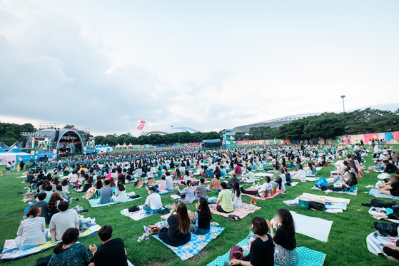 Festivalgoers at The Beautiful Mint Life 2021 music festival watch performances on picnic mats Saturday at Olympic Park in southern Seoul. The Beautiful Mint Life 2021 is Korea's first large-scale outdoor music festival to be held in a year and eight months since the Covid-19 pandemic broke out early last year. All visitors must use a self-testing kit to help ensure they do not have the virus. [NEWS1]