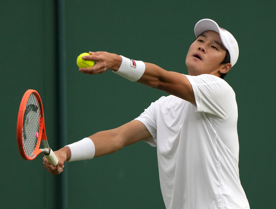Kwon Soon-woo serves to Germany's Daniel Masur during the men's singles match on day one of the Wimbledon Tennis Championships in London on Monday. [AP/YONHAP]