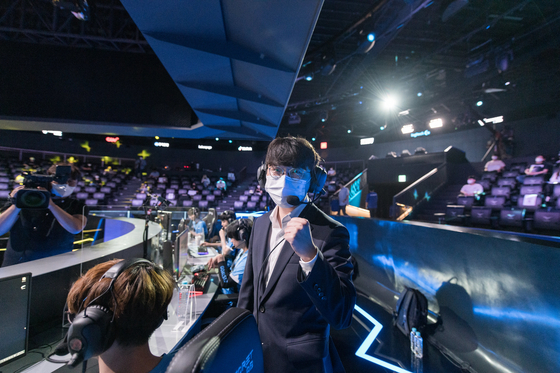 Afreeca Freecs head coach Jang ″Cain″ Nu-ri holds a pose for the cameras while his team sets up on stage. [RIOT GAMES]