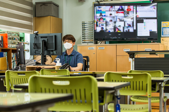 A teacher gives an online class at Muhak Elementary School in northern Seoul on Monday, as all schools in the greater Seoul area switched to online classes due to record-breaking coronavirus infections. Kids will be kept out of classrooms at least through July 25 in Seoul, Gyeonggi and Incheon. [NEWS1]
