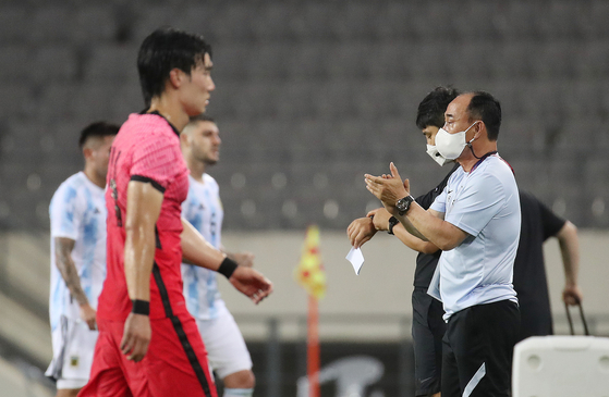 Head coach Kim Hak-bum claps after the Korean U-23 team drew with Argentina at a pre-Olympic friendly on Tuesday at Yongin Mireu Stadium in Yongin, Gyeonggi. [NEWS1]