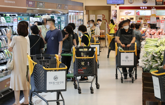 Shoppers crowd a discount supermarket's aisles on Sunday. According to major retailers including Emart, food and beverage sales have gone up between 4 and 7 percent compared to the previous week as more people stay home due to tightened social distancing regulations. [YONHAP]