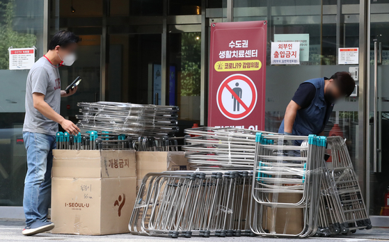 Officials unload furniture at University of Seoul in eastern Seoul on Tuesday, which will be used as a residential treatment center for Covid-19 patients with 520 hospital beds starting this day. [NEWS1]