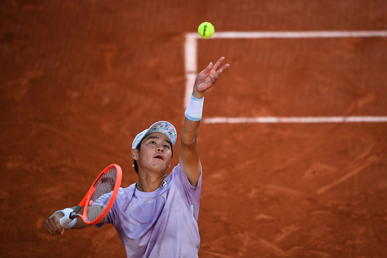 Kwon Soon-woo serves the ball to Italy's Matteo Berrettini during their men's singles third round tennis match on Day 7 of The Roland Garros 2021 French Open tennis tournament in Paris on June 5. [AFP/YONHAP]