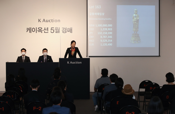 An auctioneer welcomes bids for Gilt-bronze Standing Bodhisattva at K Auction in southern Seoul last year. Kansong Art and Culture Foundation placed three art treasures up for auction last year, citing financial difficulties. [YONHAP]