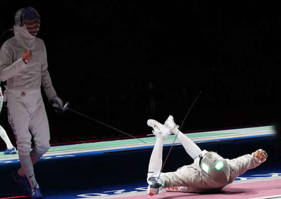 Kim Jung-hwan clenches his fists lying on the piste after winning a point against Eli Dershwitz of the United States in the men’s sabre quarterfinals on Saturday. [YONHAP]