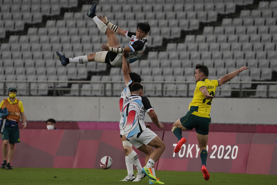 Korea's Jeong Yeon-sik is lifted in the air by teammate Lee Jink-yu during a lineout in a rugby sevens match against Australia at the 2020 Tokyo Olympics on Monday. [AP/YONHAP]