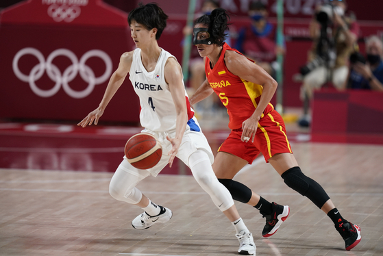 Yoon Ye-bin, left, drives around Spain's Cristina Ouvina during women's basketball preliminary round game at the 2020 Summer Olympics, on Monday in Saitama Super Arena, Saitama, Japan. [AP/YONHAP]