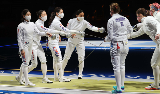 The Korean national women’s epee team salutes the United States team before the quarterfinals on Tuesday at the Makuhari Messe Hall in Tokyo. [JOINT PRESS CORPS] 