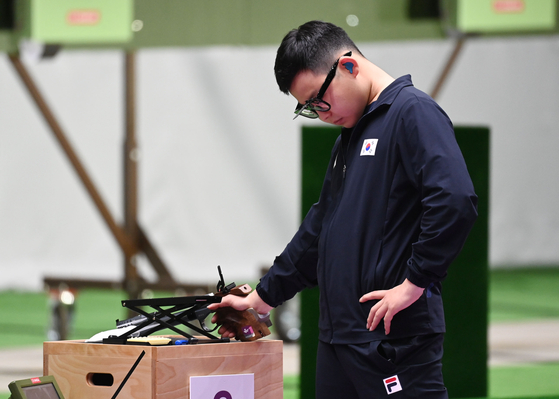 Kim Mo-se drops his head after firing a disappointing shot in the men's 10-meter air pistol event on Saturday at the Asaka Shooting Range in Tokyo. [JOINT PRESS CORPS]