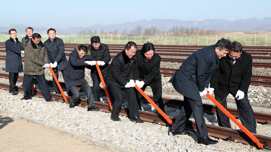 South and North Korean officials connect the rails between the two Koreas at Panmun Station in Kaesong at a symbolic groundbreaking ceremony on Dec. 26, 2018 to begin a project to reconnect their roads and railways. [JOINT PRESS CORPS]