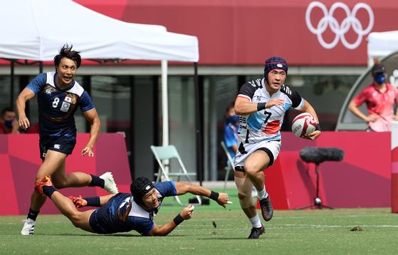 Korea's Jang Jeong-min runs with the ball during a rugby sevens game against Japan at the 2020 Tokyo Olympics on Wednesday. [YONHAP]