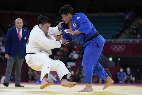 Cho Gu-ham, right, competes against Aaron Wolf of Japan in the men’s 100 kilogram judo final at Nippon Budokan in Tokyo on Thursday. [AP/YONHAP]