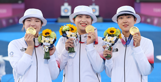 From left, Kang Chae-young, Jang Min-hee and An San of the Korean women’s archery team celebrate after winning the gold medal match in three straight sets against Russia on July 25 at Yumenoshima Park Archery Field in Tokyo. [YONHAP]