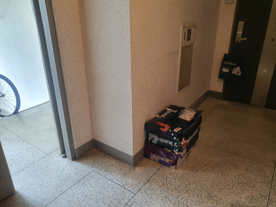 Two Fresh Bags, Coupang's reusable delivery bag, sit in front of a Ms. Choi's door in an apartment in Yongin, Gyeonggi. [JOONGANG PHOTO]