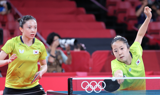 Jeon Ji-hee, left, and Shin Yu-bin compete in the table tennis women's team quarterfinals against Germany at the 2020 Tokyo Olympics on Tuesday. [YONHAP]