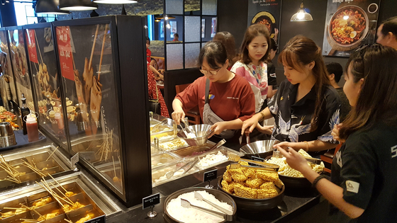 Vietnamese customers pick ingredients and sauces to cook their own tteokbokki in Dookki Topokki's Nha Trang Gold Coast branch at Nha Trang, Vietnam. [DOOKKI TOPOKKI]