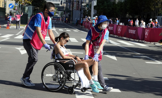 Cho Kyung-sun is helped away after crossing the finish line during the women's marathon at the Odori Park in Sapporo, Japan on Saturday. [EPA/YOHAP]