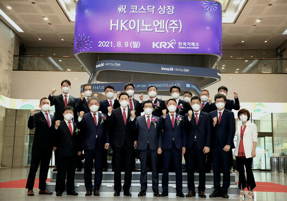 Executives including HK inno.N CEO Kang Seok-hee, center in the front row, and Ahn Byung-jun, CEO of Kolmar Korea, third from left in the front row, celebrate HK inno.N’s debut on the Kosdaq Monday at the Korea Exchange in Yeouido, western Seoul. [HK INNO.N] 