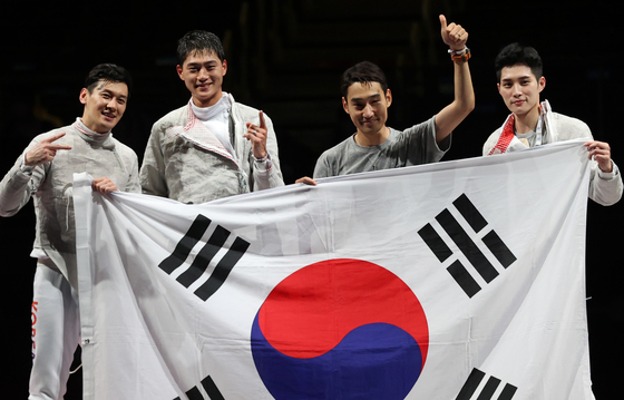 The Korean men’s sabre team celebrates after beating Italy in the gold medal match on Wednesday at the Makuhari Messe Hall in Chiba, Japan. With the gold, Korea successfully defended the men’s team sabre title it has held since the London 2012 Olympics. [YONHAP]