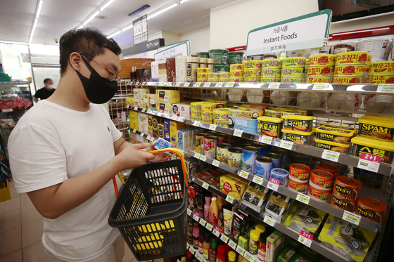 A customer shops at a convenience store in Seoul on Aug. 4. The service industry and retail sales grew in the second quarter. The government emergency relief grant while designed to help boost such retail sales, the ongoing resurgence of Covid-19 is expected to undercut such efforts. [YONHAP] 