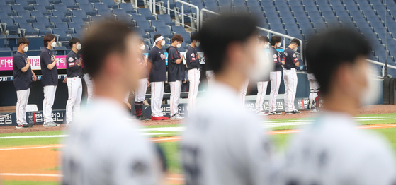 The NC Dinos and Lotte Giants line up at the start of a game at Changwon NC Park in Changwon, South Gyeongsang on Tuesday. The KBO resumed on Tuesday after a one-month break for the Tokyo Olympics that started early due to a Covid-19 outbreak that began when NC players broke social distancing regulations. [YONHAP]