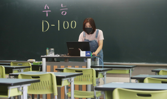 A teacher instructs her high school senior students online in an empty classroom at Suwon High School in Suwon, Gyeonggi, on Tuesday, 100 days before the College Scholastic Ability Test (CSAT). The students are taking online classes at home because of the Covid-19 pandemic. [YONHAP]