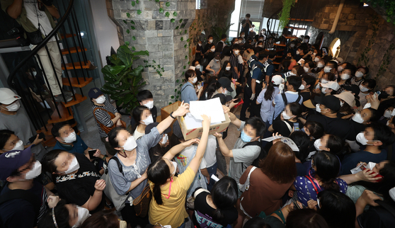 Customers fill the headquarters of Mergeplus on Friday afternoon in Yeongdeungpo, western Seoul, demanding refunds after the company reduced the number of affiliated shops and stopped selling Mergemoney on Aug. 11. [YONHAP]