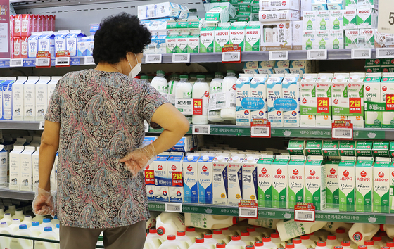A customer looks at milk displayed at discount mart in Seoul on Wednesday. [NEWS1]