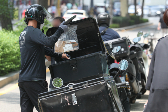 A delivery worker makes a delivery in Jongno District, central Seoul, on July 12. [NEWS1]