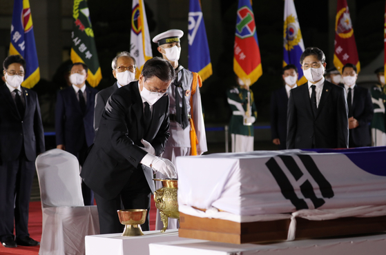 President Moon Jae-in pays respects to the remains of Hong Beom-do, a heroic Korean independence fighter repatriated from Kazakhstan 78 years after his death, at Seoul Air Base in Seongnam, Gyeonggi, in a late-night ceremony Sunday, coinciding with Liberation Day. [YONHAP]
