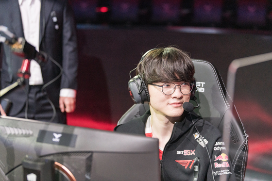 T1 mid laner Lee ″Faker″ Sang-hyeok smiles while setting up on stage. [RIOT GAMES]