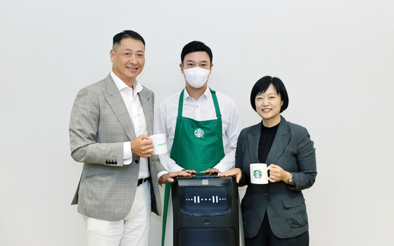 Starbucks Korea CEO Song Ho-seob, left, and Naver CEO Han Seong-sook, right, pose for a picture after signing a memorandum of understanding. [NAVER]