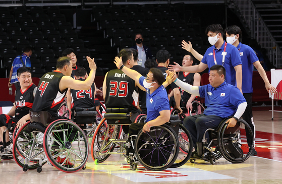 Members of the Korean wheelchair basketball team are consoled by team staff after their defeat against Spain on Wednesday evening. [REUTERS/YONHAP]