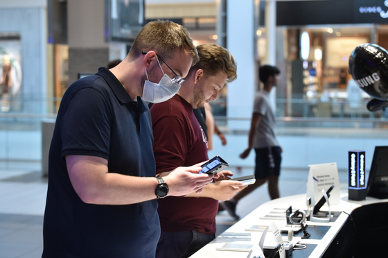 Customers look at new Galaxy Z Fold 3 and Galaxy Z Flip 3 foldables at the Samsung Experience Store in Garden City, New York. [SAMSUNG ELECTRONICS] 