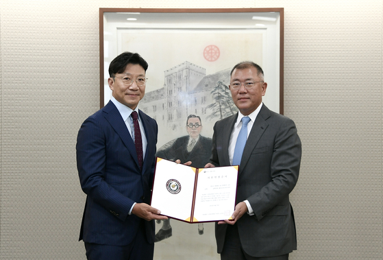 Hyundai Motor Group Chairman Euisun Chung, right, and Kim Jae-ho, chairman of Korea University Foundation pose for a photo at Korea University on Tuesday after signing a donation agreement. [HYUNDAI MOTOR GROUP]